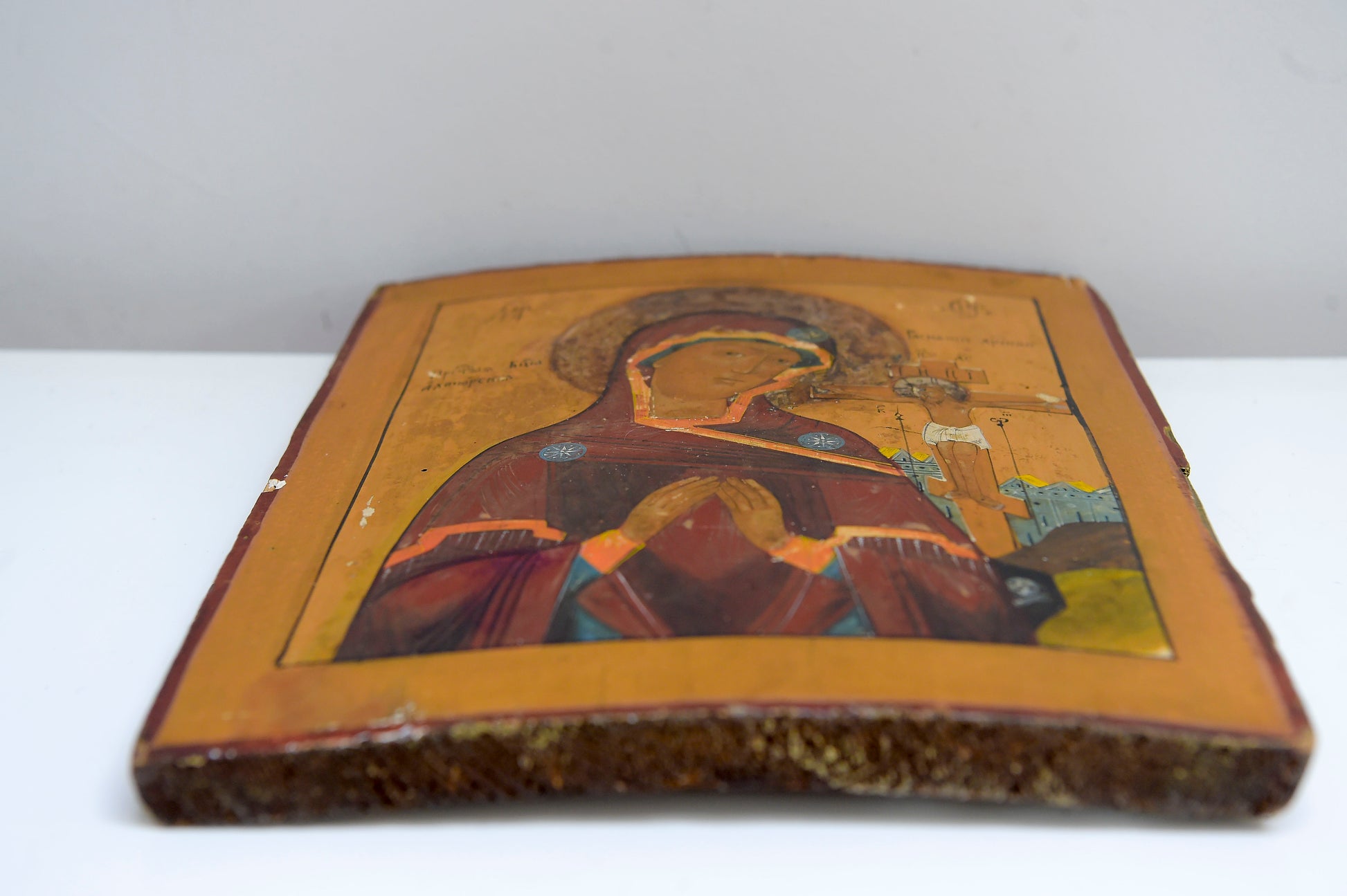 19TH CENTURY Antique Russian Icon on a Curved Wooden Panel. Mother of God and the crucifixion of christ The Wood panel has two reinforcement slats and text to the back.