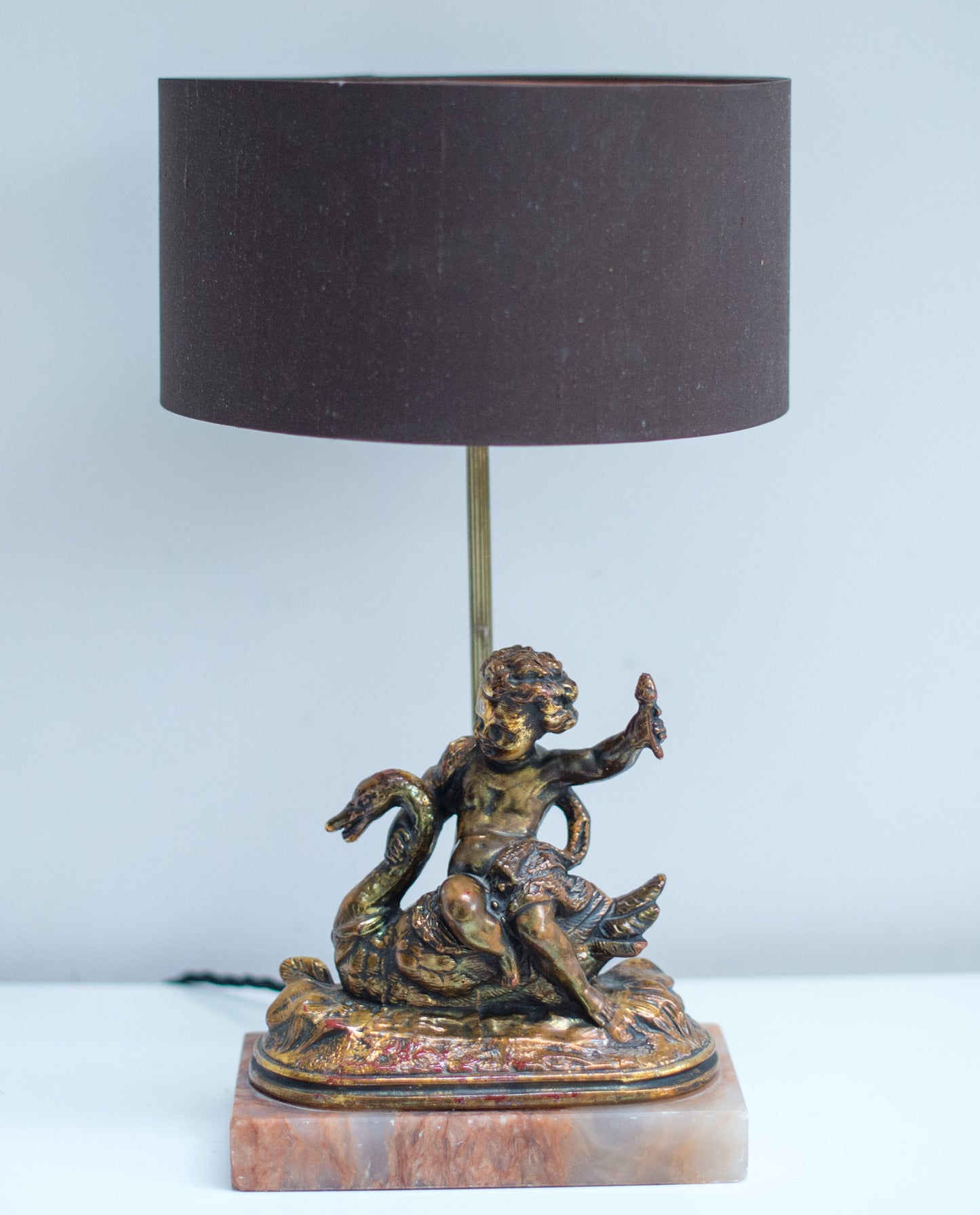 A gilt composition cherub figural table lamp cherub seated on a swan